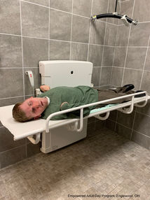Man demonstrating universal changing table pressalit 1000 at Empowered adult say services Dayton Ohio