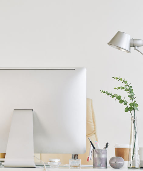 Schreibtisch mit Bildschirm und Tischlampe