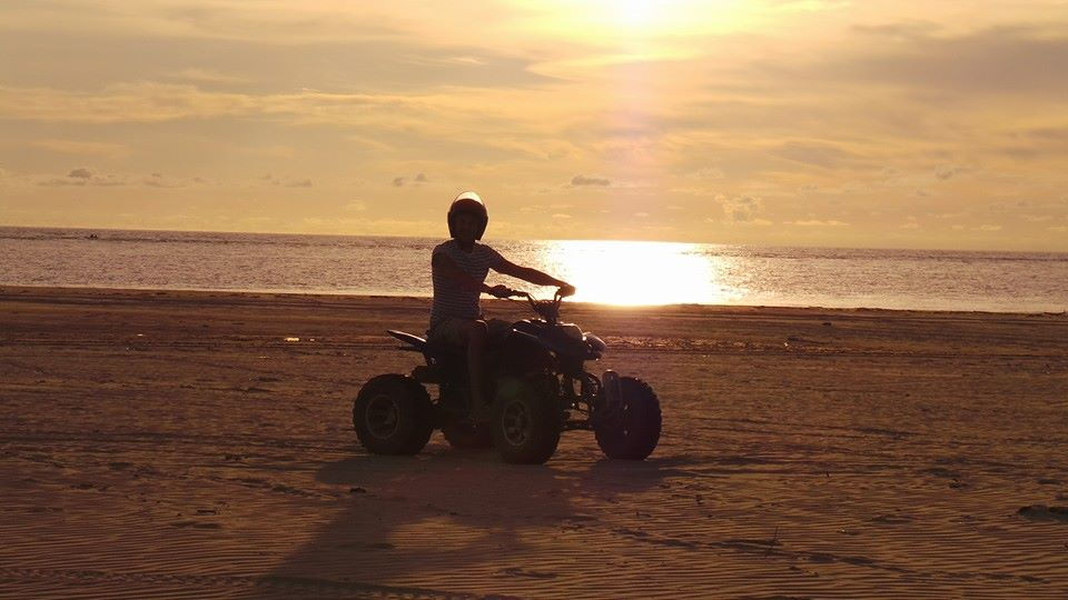 Quad biking on the beach at sunset