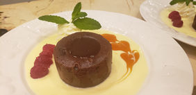 Molten chocolate cake dessert with raspberry sauce