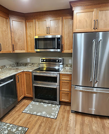 a kitchen featuring_ Cabinetry_ Medium-wood tone cabinets with dark hardware. Countertops
