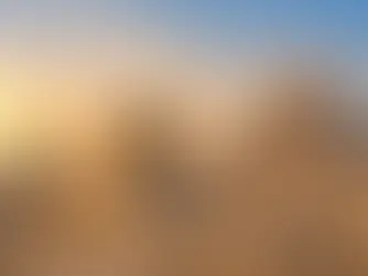 Sfinksen og pyramidene i Giza i Egypt ved solnedgang, med gyllent ørkenlandskap.