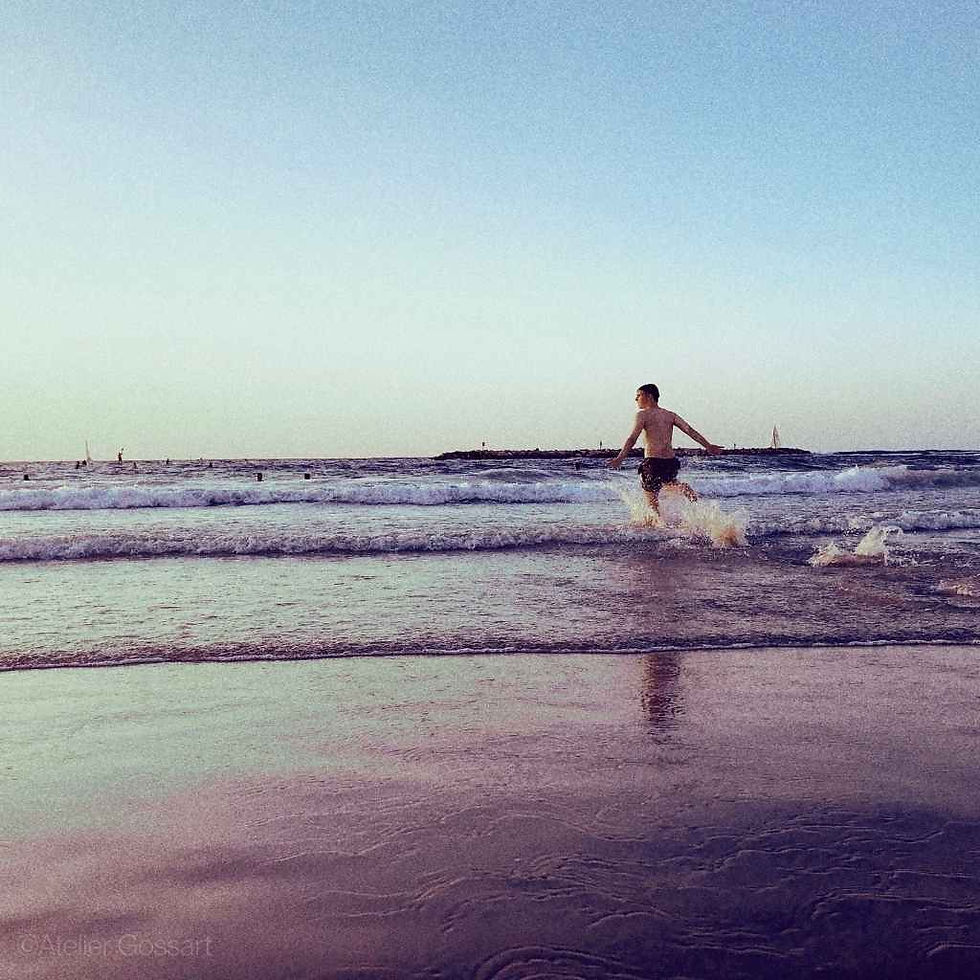 Boy running into ocean waves at the beach embodying freedom