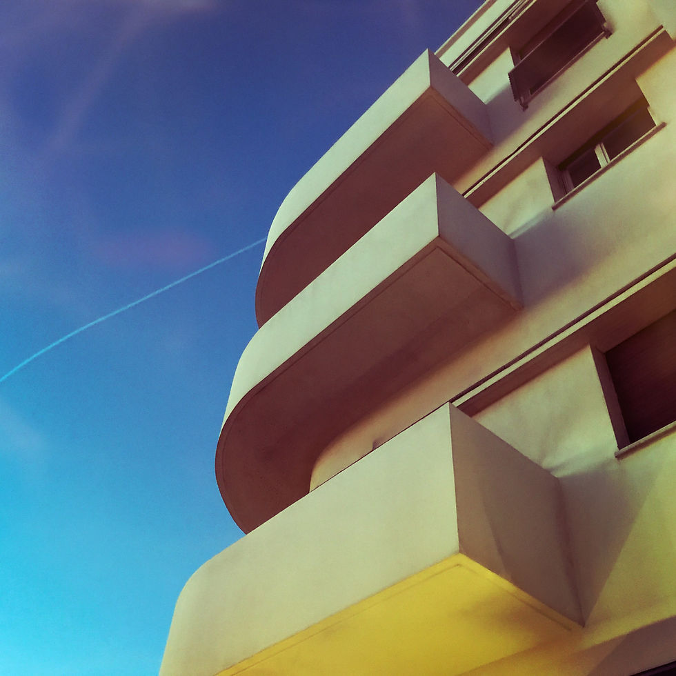 Low-angle view of Bauhaus 6 building balconies against blue sky.