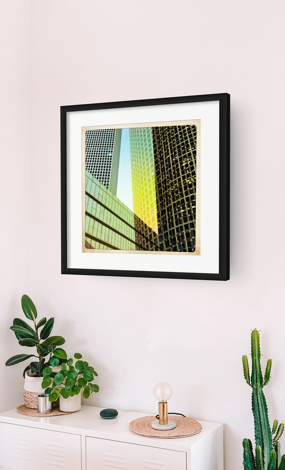 Framed art of Azrieli towers in a modern office setting with plants