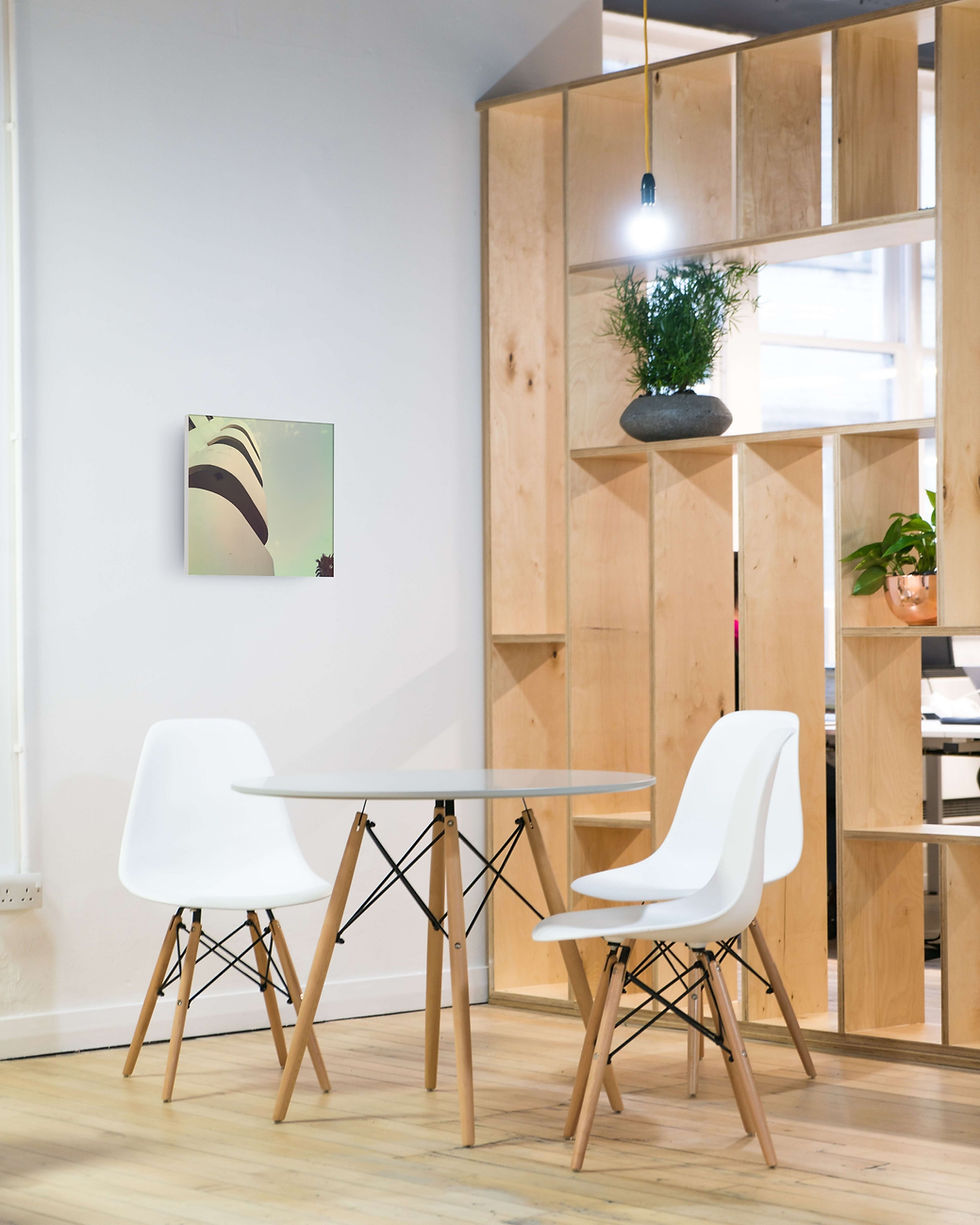 Modern Bauhaus-style dining area with round glass table.
