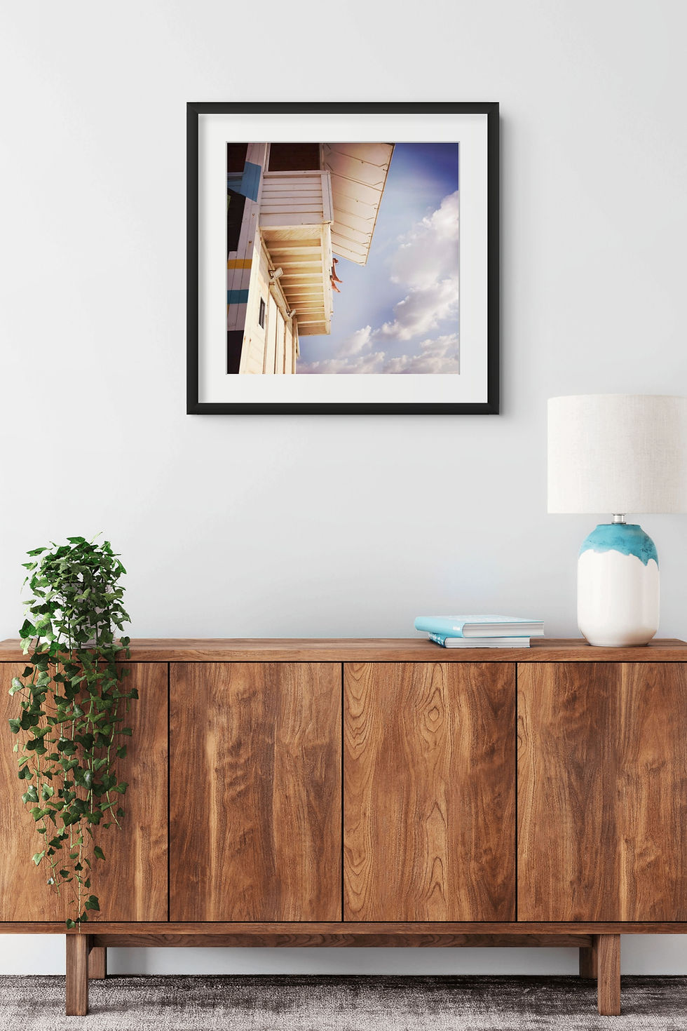 On Duty framed print on a white wall above a wooden side table
