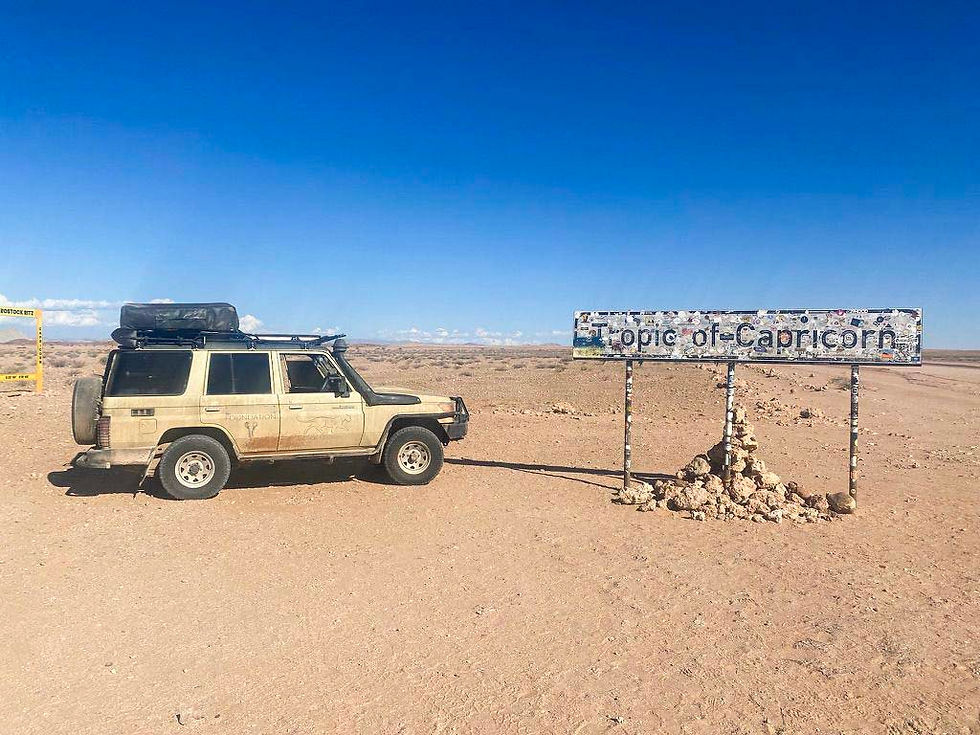 Safari vehicle in remote desert landscape in Namibia with dry plains and wide open skies