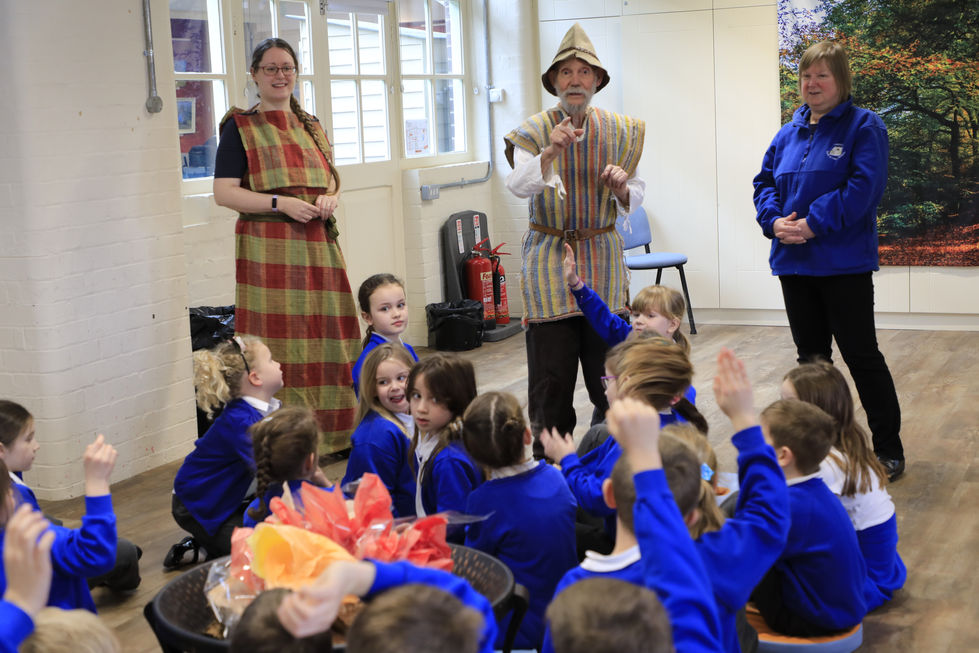 Class of children taking part in a learning session with costumed group leaders