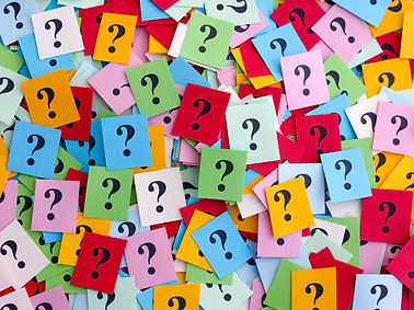 Too Many Questions. Pile of colorful paper notes with question marks. Closeup..jpg