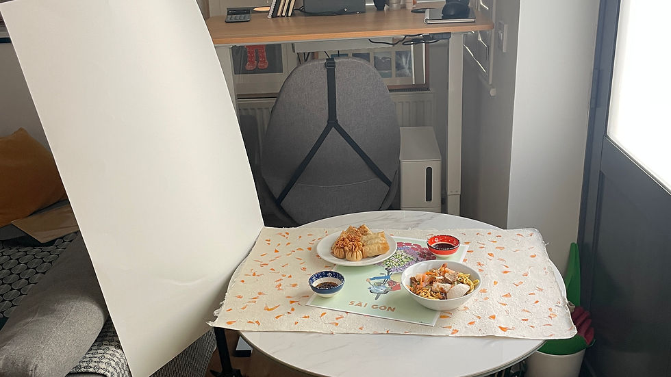 Table with snacks under bright light setup, in a cozy room with plants, books, and a standing desk. Shoes are near the door.