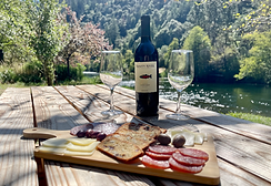 Riverside picnic at Trinity River Farmhouse with a charcuterie board, wine, and scenic river views.