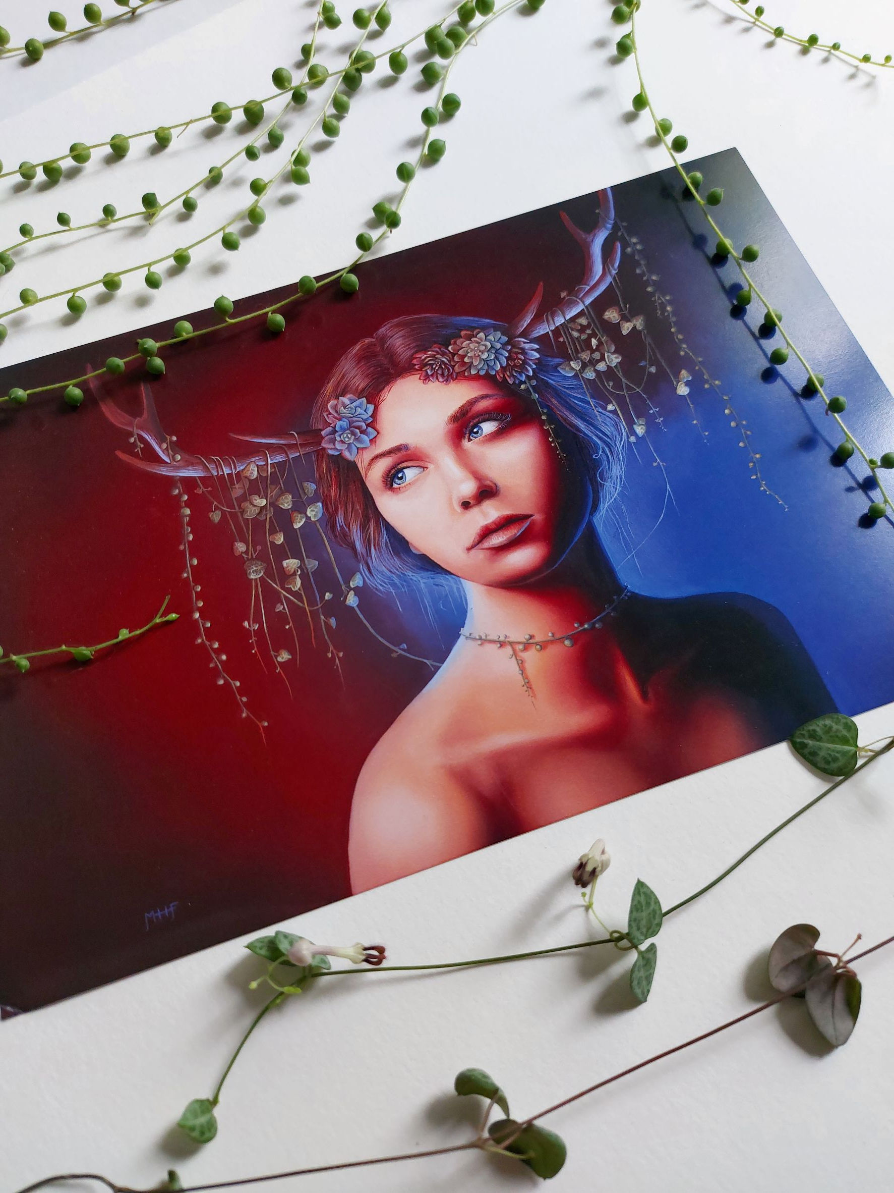 A photograph of fine art prints by New Zealand artist Mikayla Forster. This art print depicts a female portrait with flowers