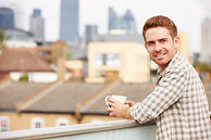 young man looking at camera on balcony.J