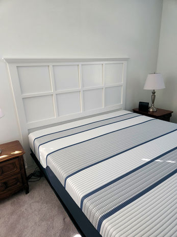 Headboard built into wall above bed with striped comforter