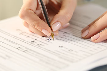 A woman is filling out medical forms, realizing she doesn't have a contact person.