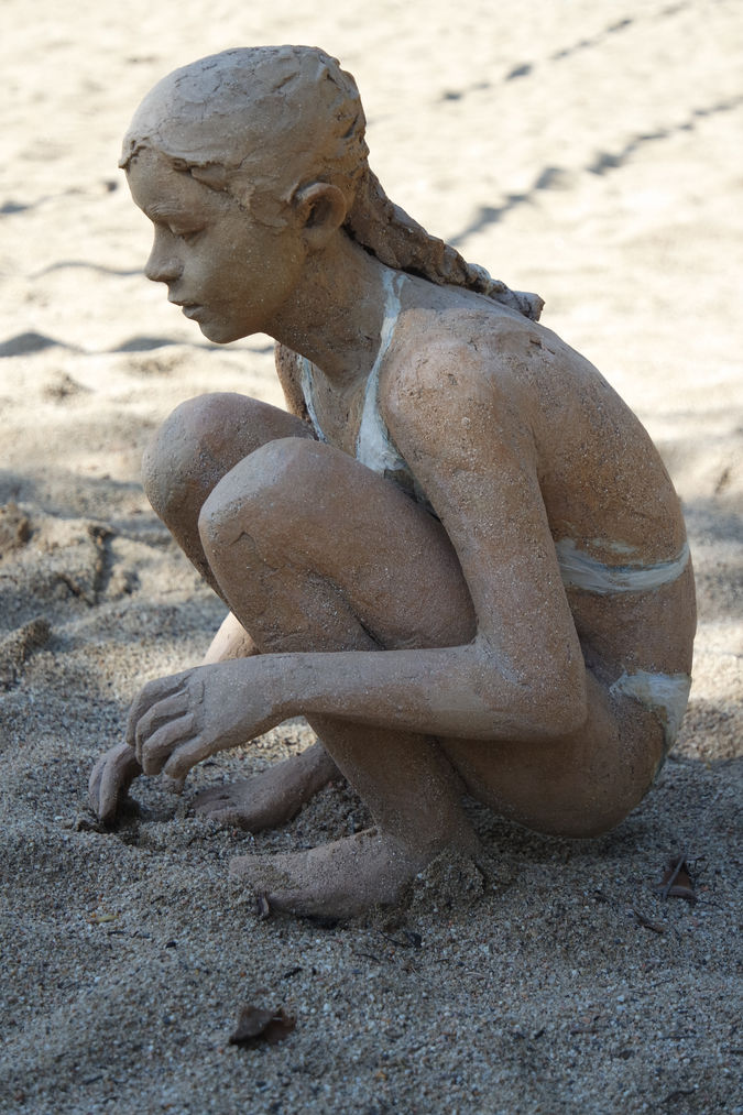 Sculpture grès. Enfance. Jeune fille accroupie sur le sable