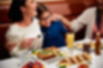 Family laughing together while enjoying breakfast