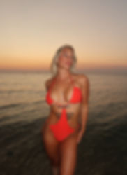 Woman in red bikini at sunset beach