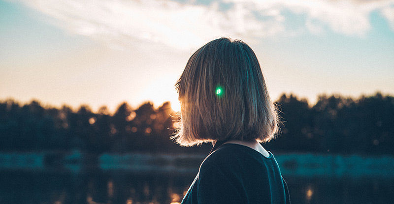 woman staring off towards the sun rising. how to become resilience with niagara counselor ian robertson