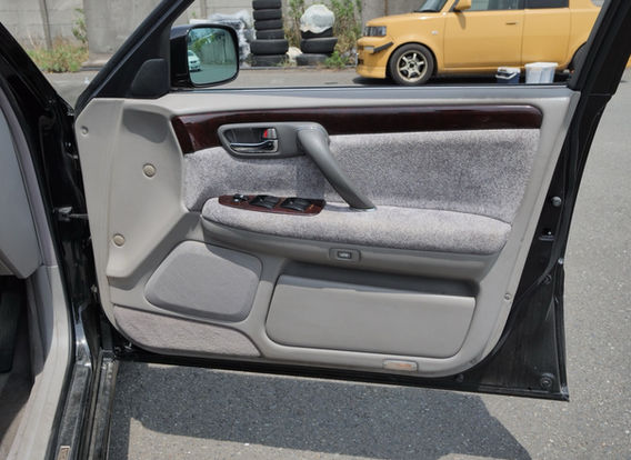 Interior of 1999 Toyota Crown Majesta 3.0 showing black seat covers, front power seats, navigation system, automatic transmission, and keyless entry – luxury JDM car for sale