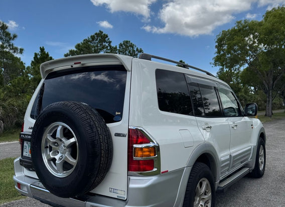 Right-hand drive 1999 Mitsubishi Pajero Long Exceed 4WD for sale by JDM Importer Lion JDM Imports LLC – side view of a rugged, silver SUV, showcasing its 4WD capabilities, spacious design, and well-maintained exterior, perfect for JDM car enthusiasts.