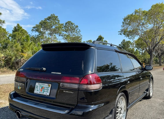 The rear of a 1996 Subaru Legacy Wagon GT-B, highlighting its wagon design, taillights, and subtle rear spoiler.