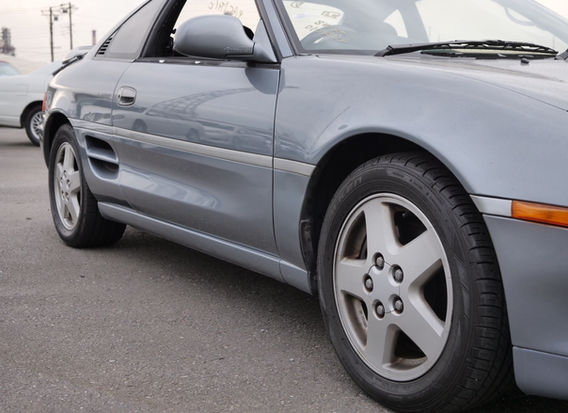 Side profile of 1995 Toyota MR2 G Limited Steel Mist Grey with alloy wheels and clean body lines.