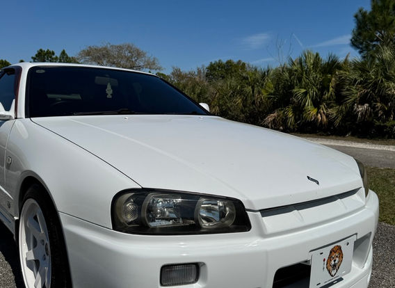 Front view of the Nissan Skyline R34 GTT showcasing its factory Xenon headlights and iconic JDM styling.