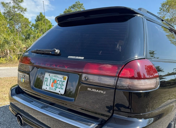 The rear of a 1996 Subaru Legacy Wagon GT-B, highlighting its wagon design, taillights, and subtle rear spoiler.