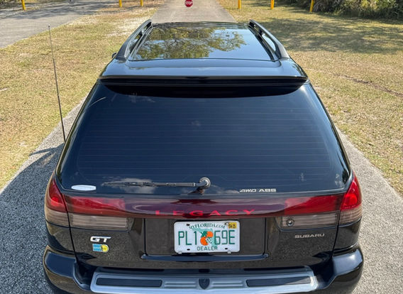The rear of a 1996 Subaru Legacy Wagon GT-B, highlighting its wagon design, taillights, and subtle rear spoiler.