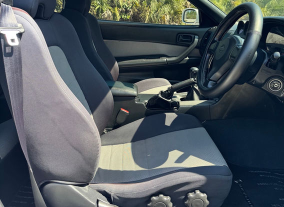 Interior of the 1998 Nissan Skyline R34 GTT showcasing factory 'Skyline' carpets and original trim.