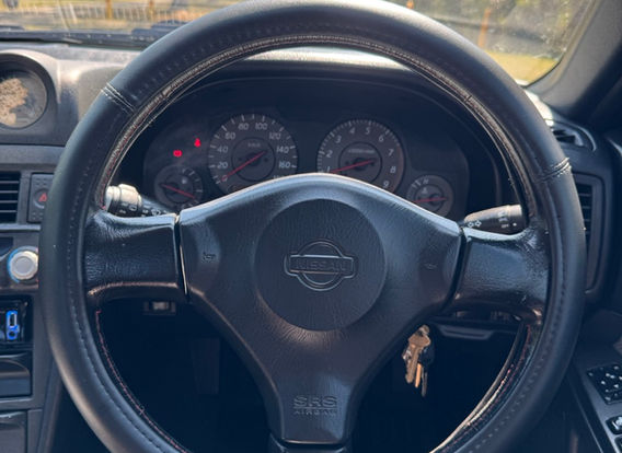 Interior of the 1998 Nissan Skyline R34 GTT showcasing factory 'Skyline' carpets and original trim.