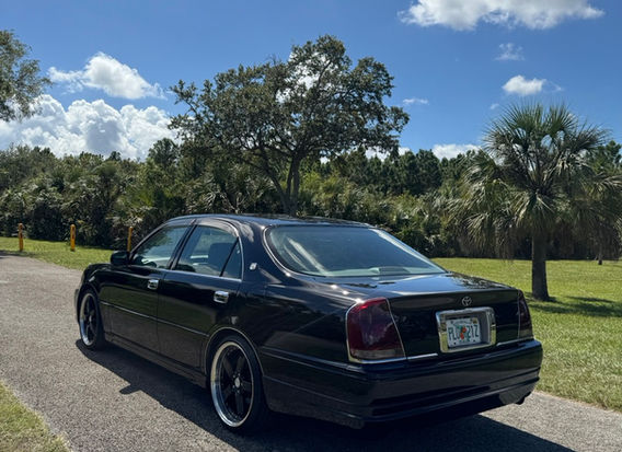 Rear view of 1999 Toyota Crown Majesta 3.0 with original black paint, aftermarket aero, and adjustable suspension – luxury Japanese sedan with keyless entry