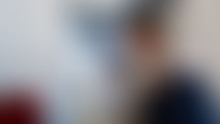 Plumber inspecting pipes under a sink to assess plumber leak detection cost and locate a hidden leak