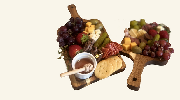 2 charcuterie boards with assorted cured meats, cheese, dips,fruits, sweet treats, crackers, and vegetables honey