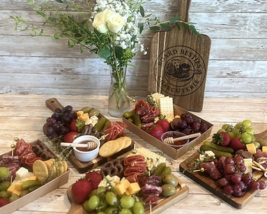 Board Besties, Mobile Charcuterie Catering, possible variations of charcuterie boards and boxes with different assorted meats, cheeses, fruits, vegetables, sweet treats, dips, and crackers.