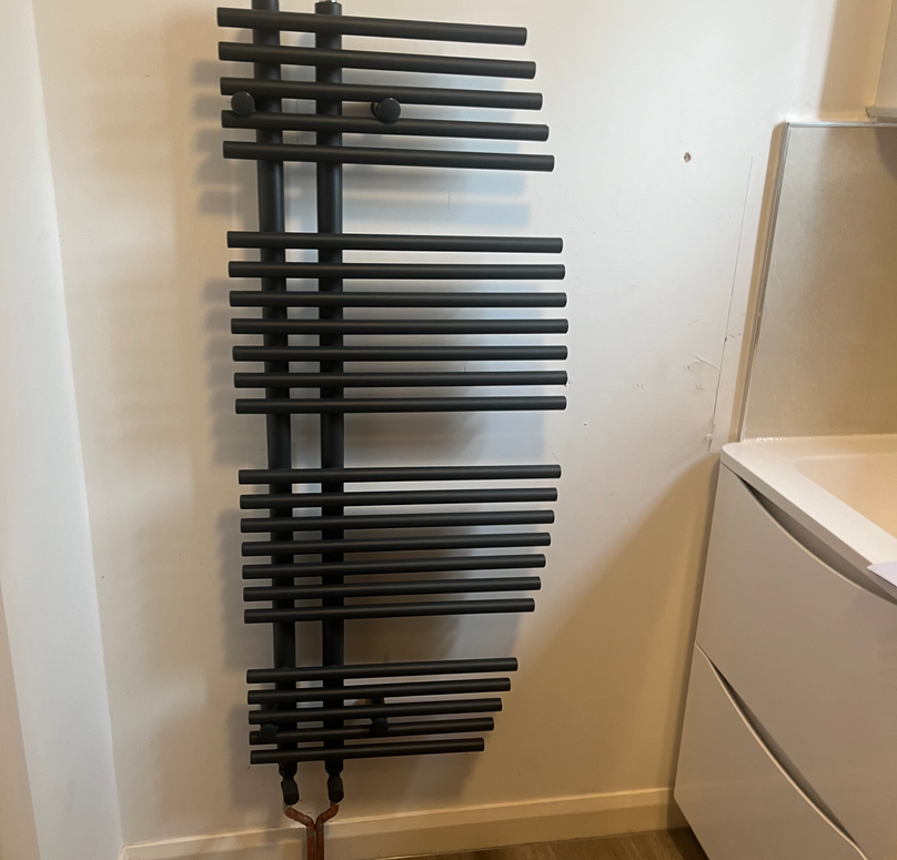 A modern black towel rail with a staggered edge effect