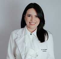 Mulher jovem e fisioterapeuta, sorrindo e segurando uma pelve de pano com os orgãos pélvicos de pano.