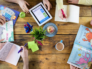 Children exploring a homeschool curriculum, books and other learning materials at home.