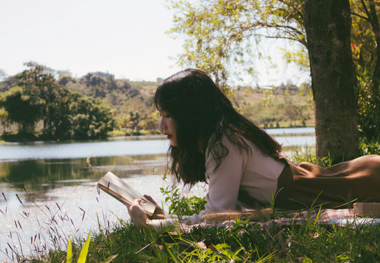 Woman reading Shakespeare by a river