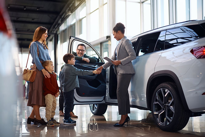 happy-black-saleswoman-greeting-a-family-at-car-de-2026-03-11-22-51-47-utc.jpg