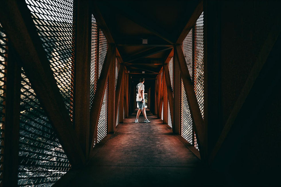 En gutt i en mørk tunnel laget av jern og gitter. Mye kontraster. William Fabian Stang.
