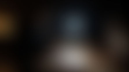 two people sit at a desk with a strong light between them