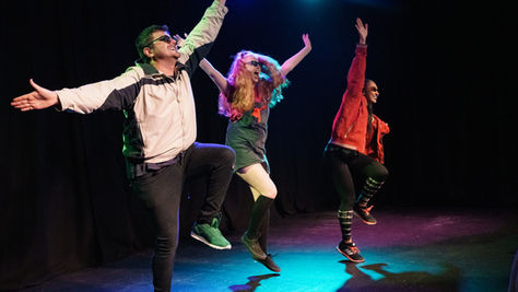 people performing on stage, dancing together