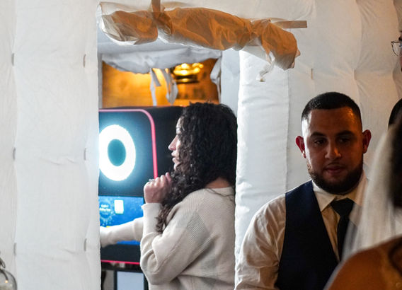 Assistan helping guest in enclosed photo booth.