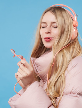 A Woman Wearing Pink Coat and Headphones