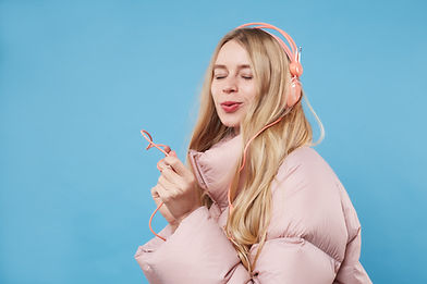 Una mujer con abrigo rosa y auriculares