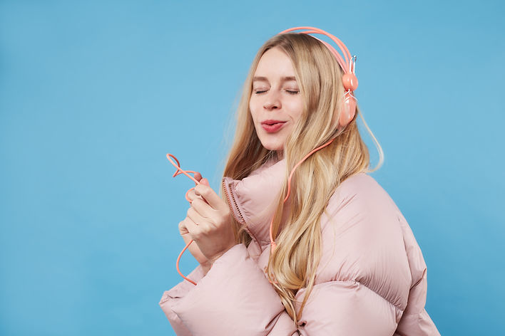 A Woman Wearing Pink Coat and Headphones