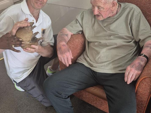 Gareth North, from Mitcham Zoo, with Arlo the armadillo and John Deevey, a resident at HC-One's Fieldway Care Home in Mitcham, Surrey.